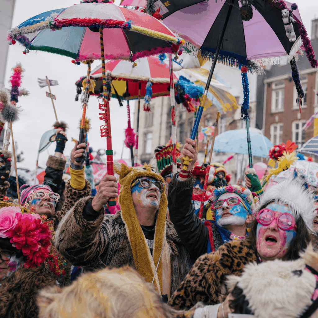 Des carnavaleux portent des parapluies décorés et colorés au-dessus de la foule pendant une ambiance festive inspirée du Carnaval de Dunkerque.