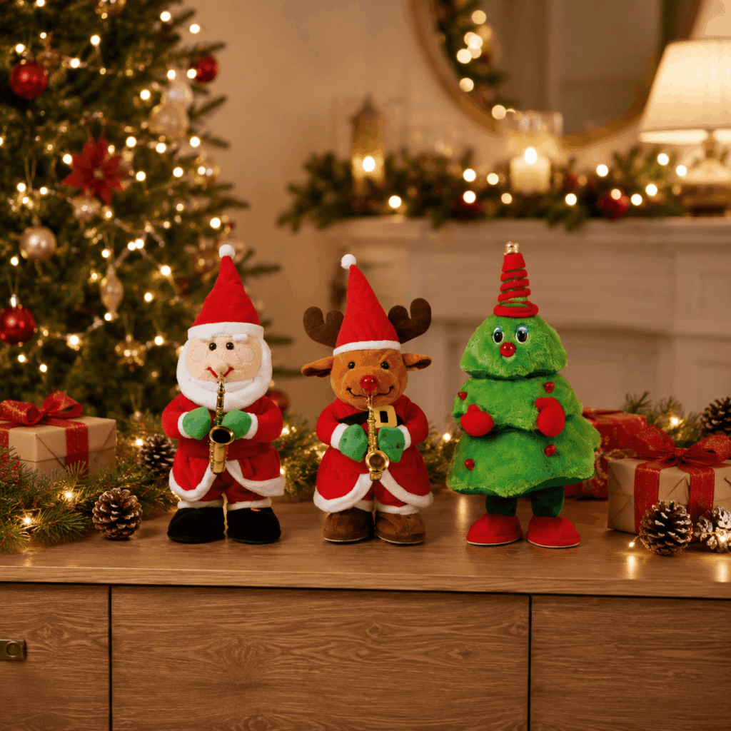 Trois petits automates interactifs de Noël de 40 cm, Père Noël, renne et sapin, posés sur une console décorée avec guirlandes lumineuses, cadeaux et sapin en arrière-plan.